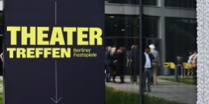 Ein dunkelblaues Plakat mit dem gelben Schriftzug „Theatertreffen“ vor dem Haus der Berliner Festspiele