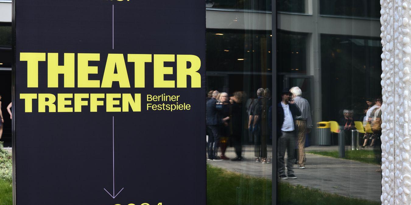 A dark blue poster with the yellow lettering “Theatertreffen” in front of the Haus der Berliner Festspiele