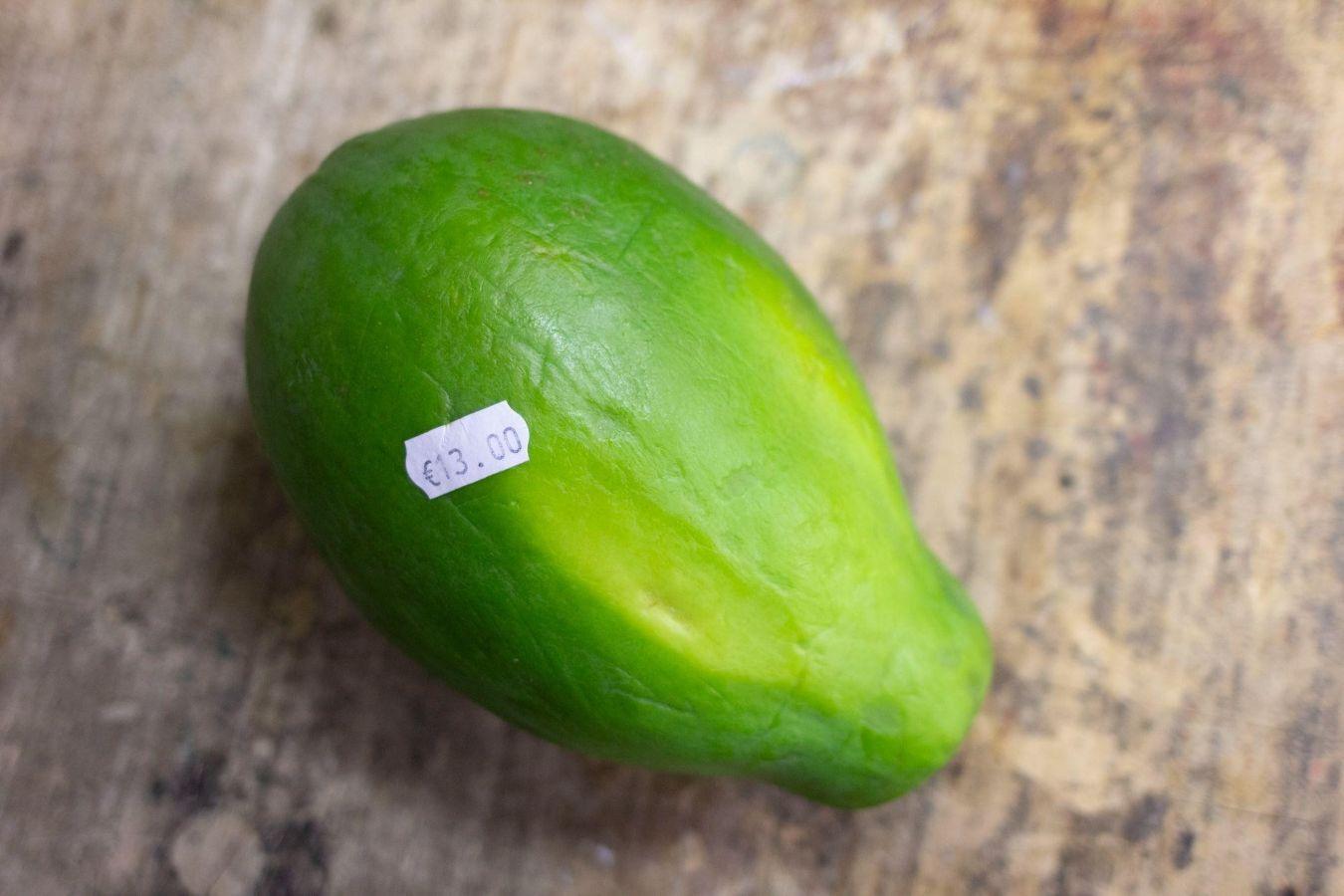 A bright green papaya with a price tag labelled ”€13.00“.