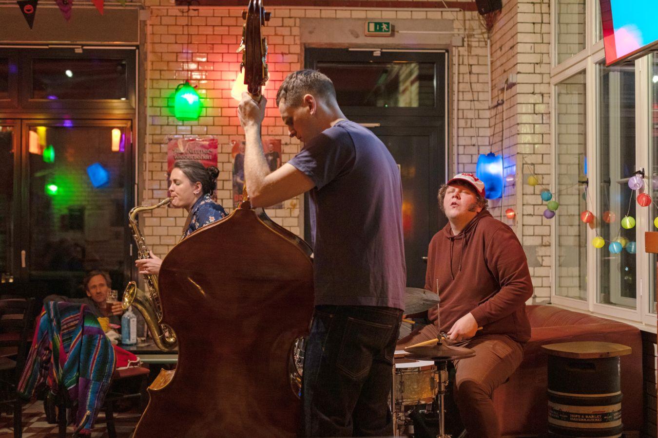 Three musicians play in atmospheric surroundings. Small lanterns are hung up.