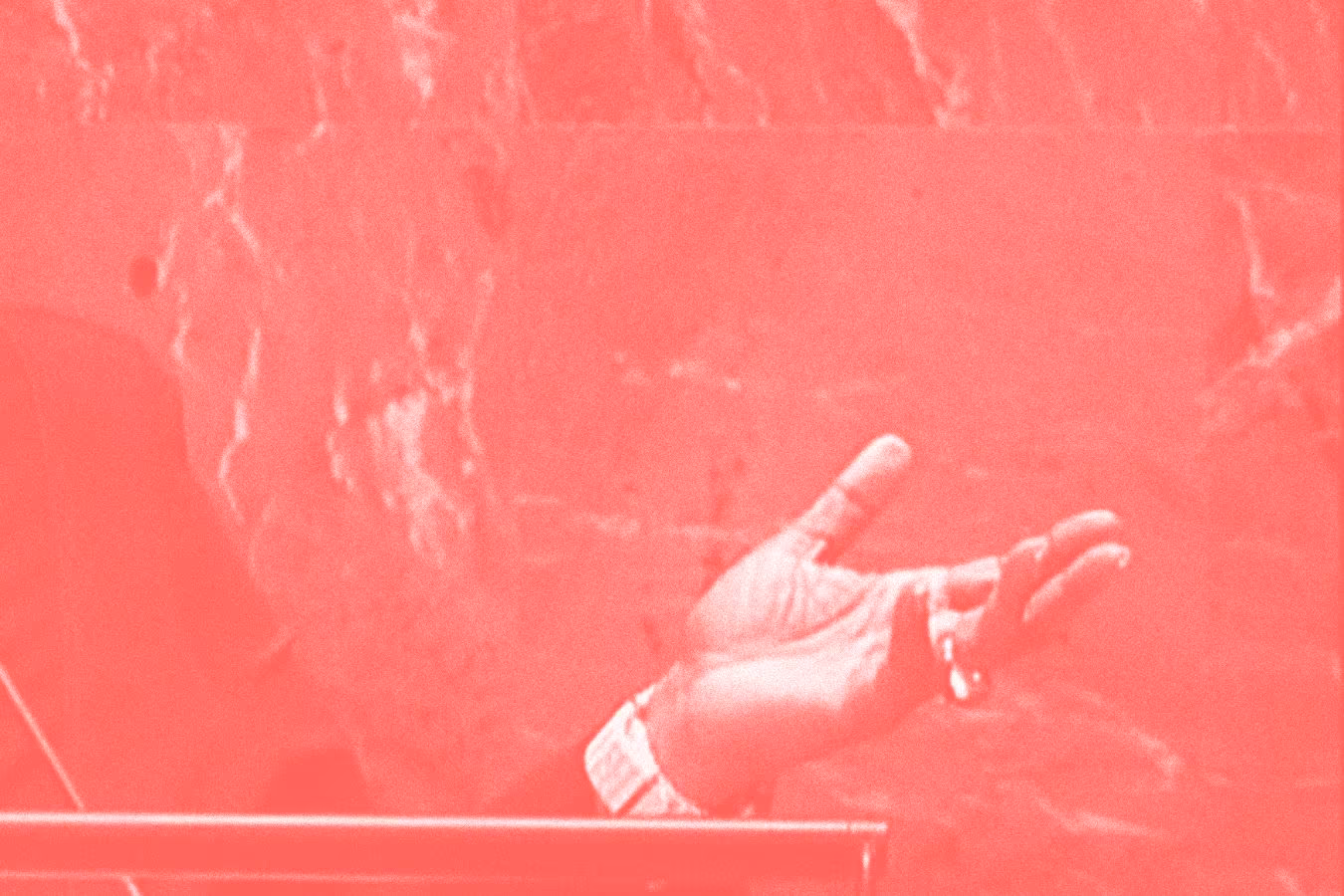 A left hand in an inviting gesture. The photo is reddish in colour and appears archival.