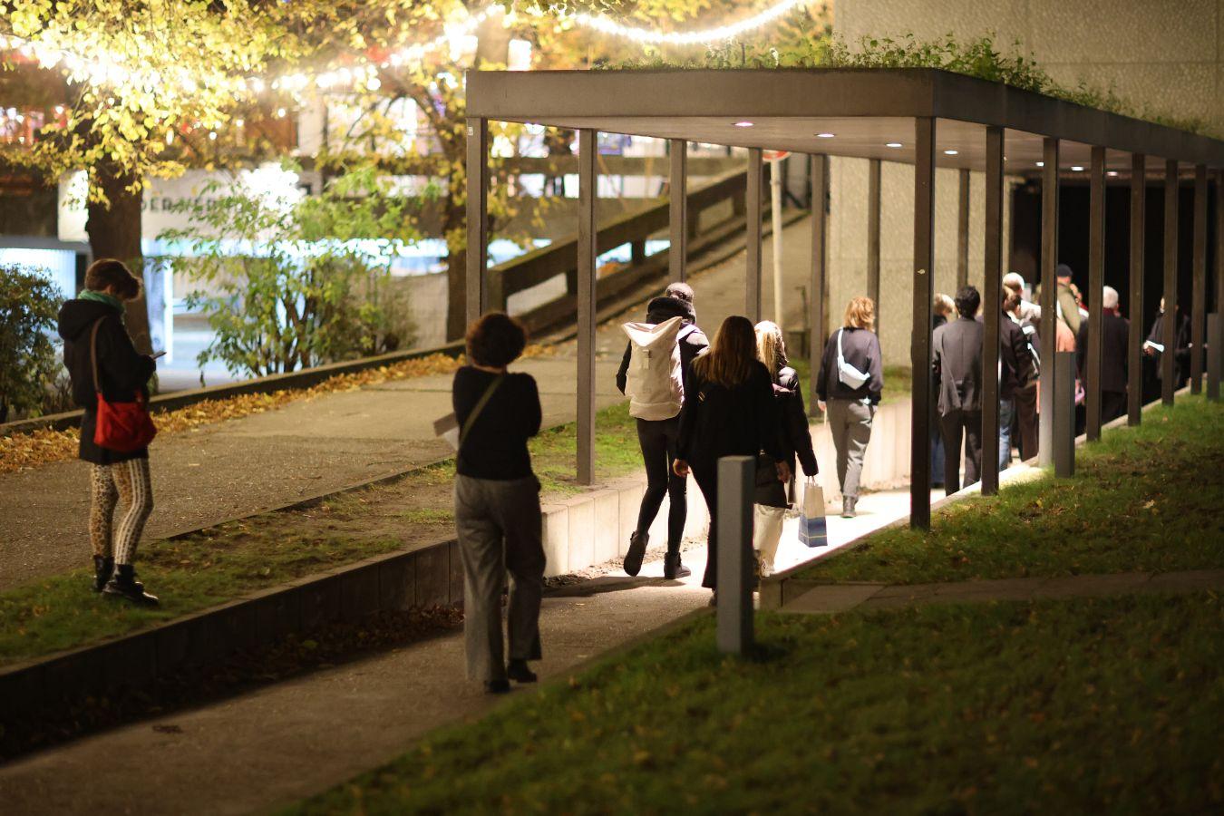 Several people run to the entrance of the side stage of the Haus der Berliner Festspiele.