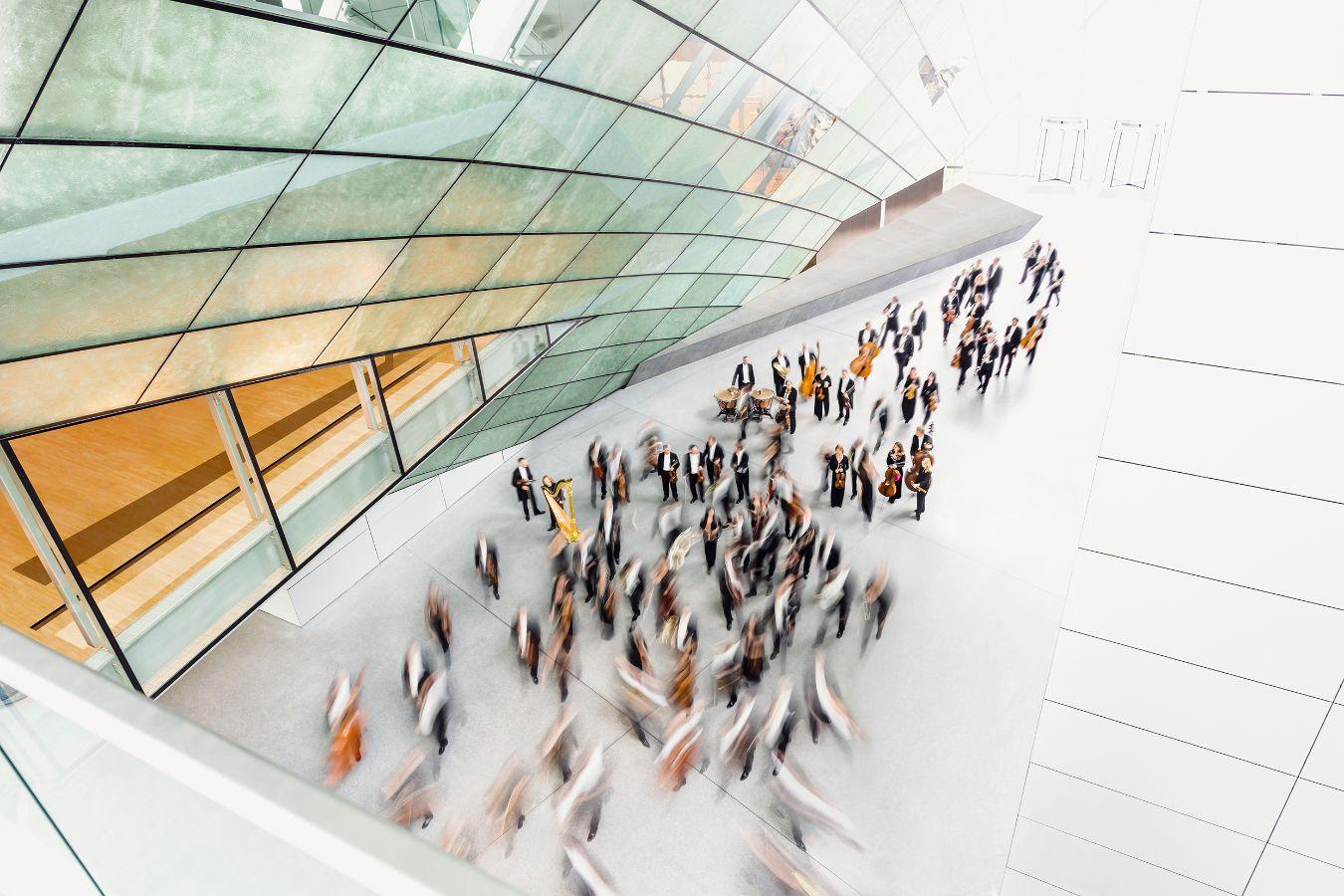 Portrait of the hr-Sinfonieorchester from a bird’s eye view and partially blurred due to movement.