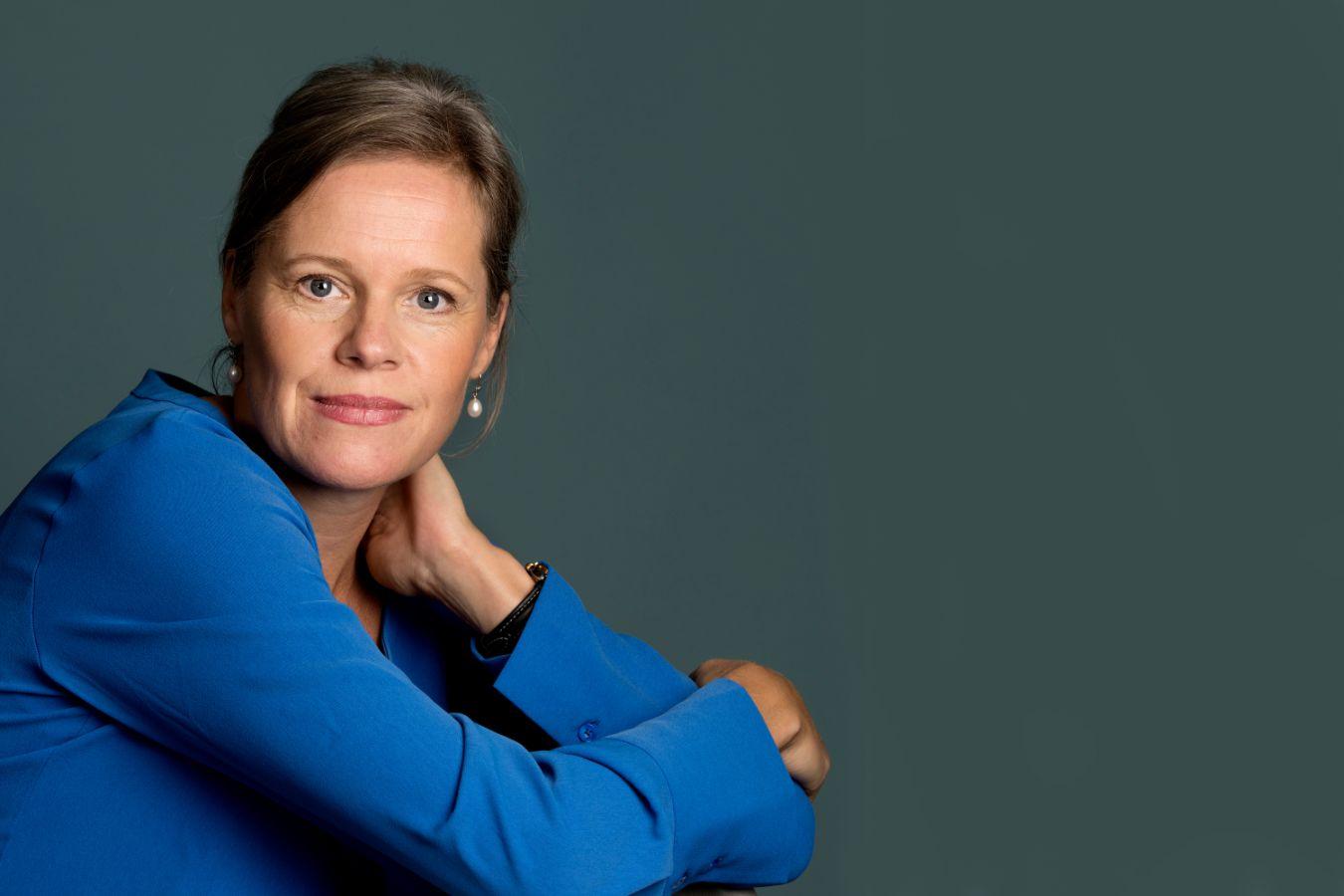 Porträt: Tilling lehnt die Arme auf ihre Knie und dreht den Kopf in die Kamera.