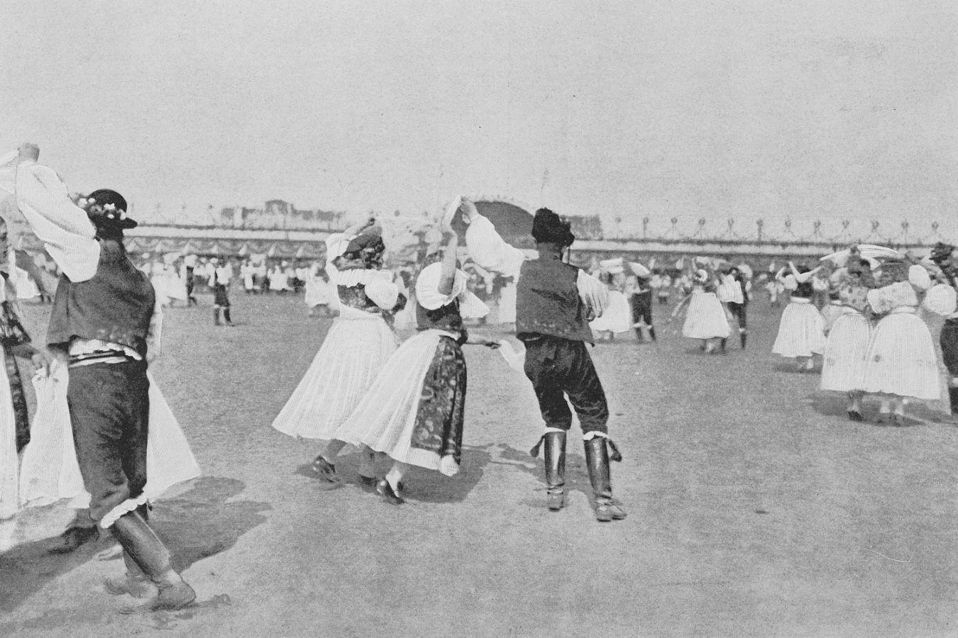 Frauen und Männer in traditionellen Trachten beim Tanzen