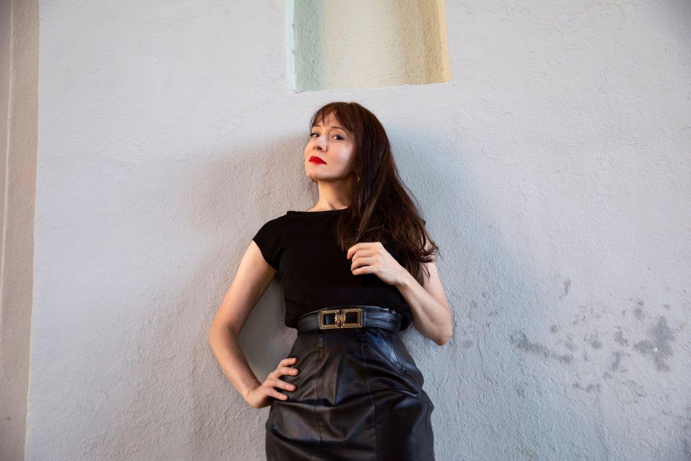 Sánchez leans on a wall, her gaze is dreamy