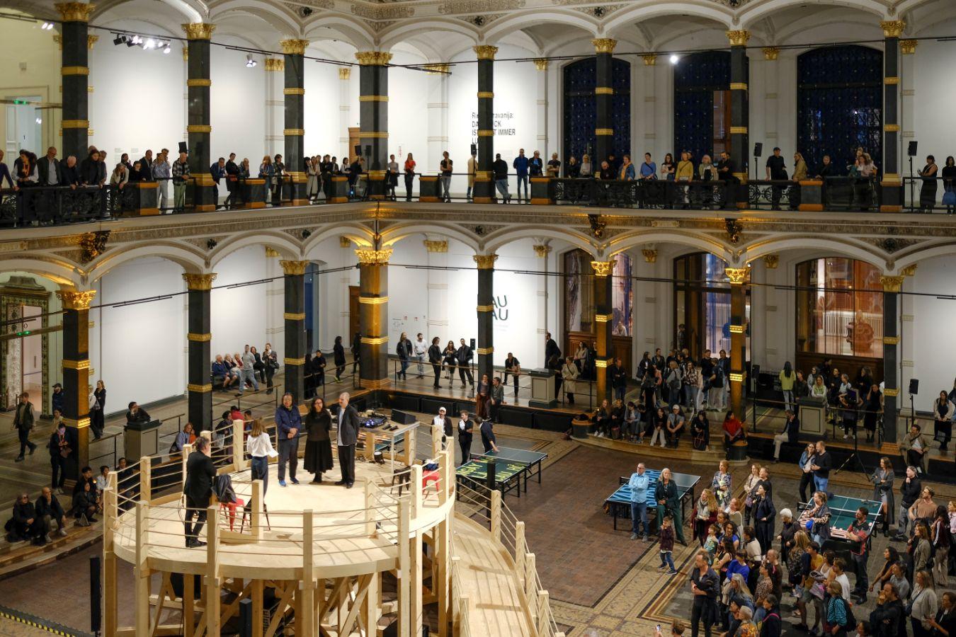 Many people are gathering in the atrium of Gropius Bau at an opening event.