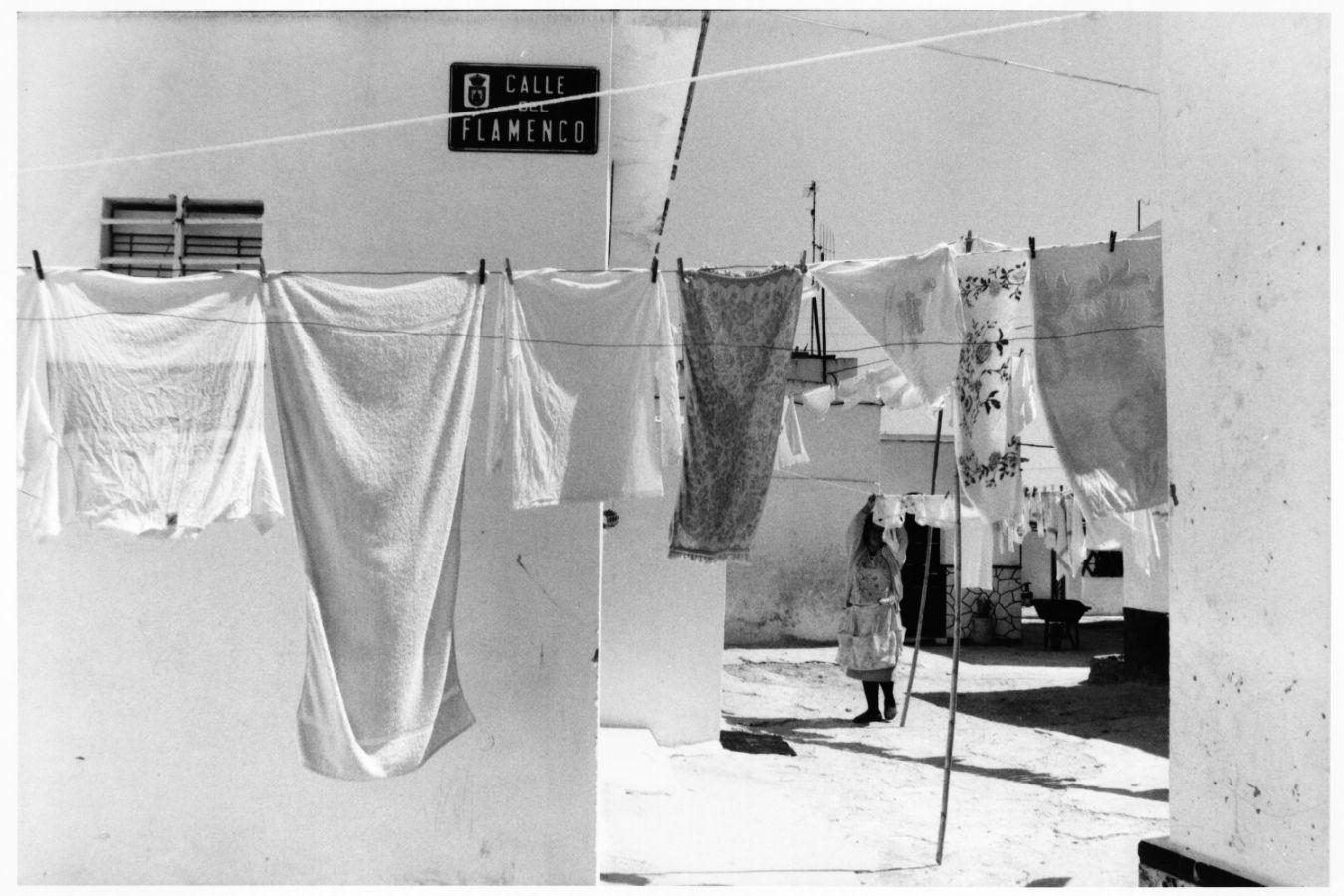 Clotheslines in a courtyard; a woman can be seen in the background.
