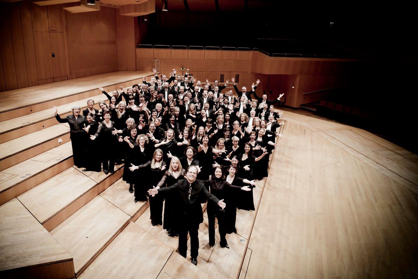 Der Philharmonische Chor München steht auf einer leeren Bühne