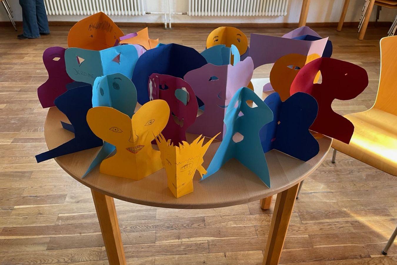 Bunte Scherenschnitte in Form von kleinen Figuren und Gesichtern