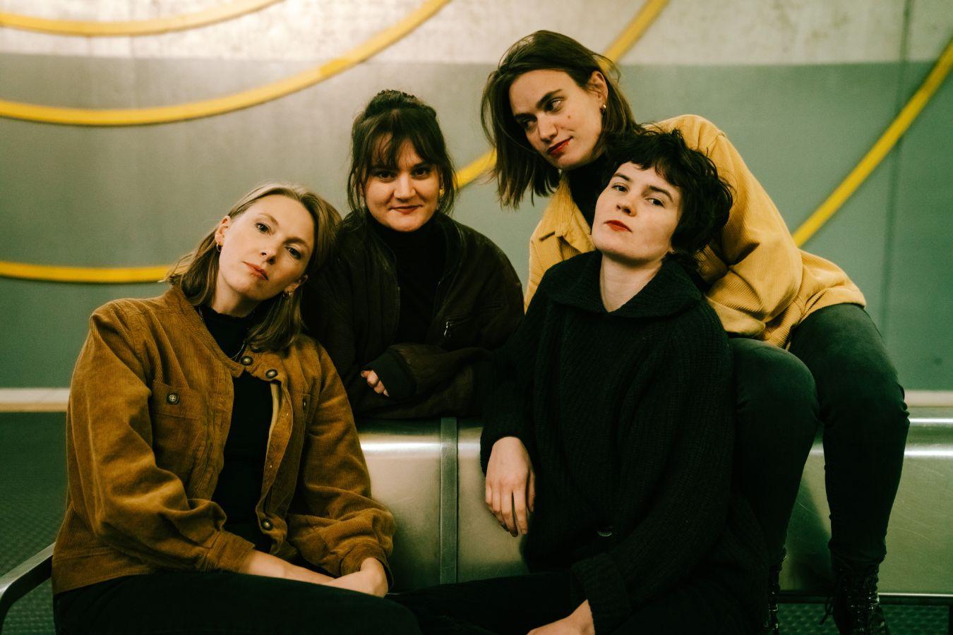 Vier Frauen auf einer Metallbank