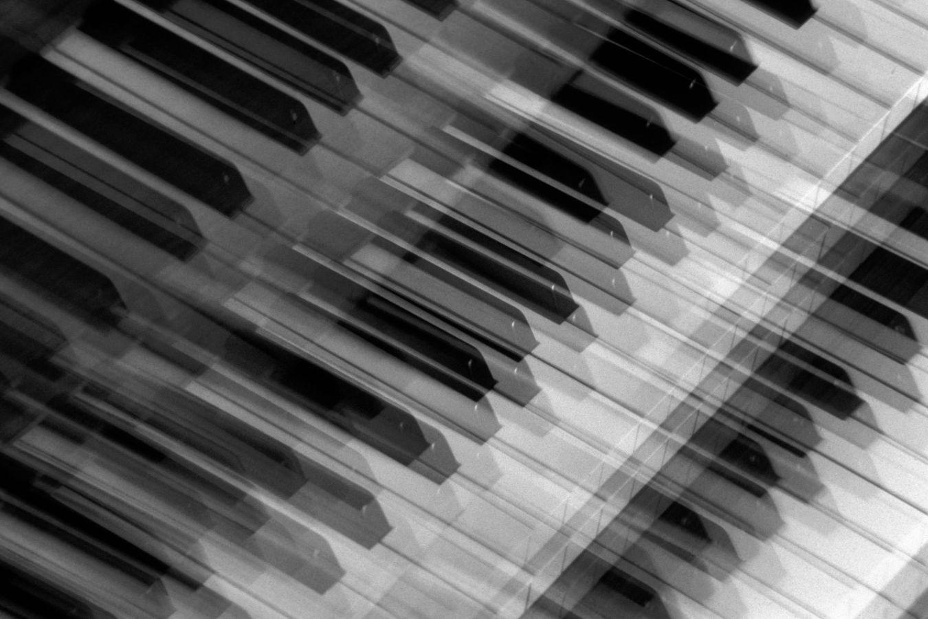 Three blurred piano keyboards one on top of the other