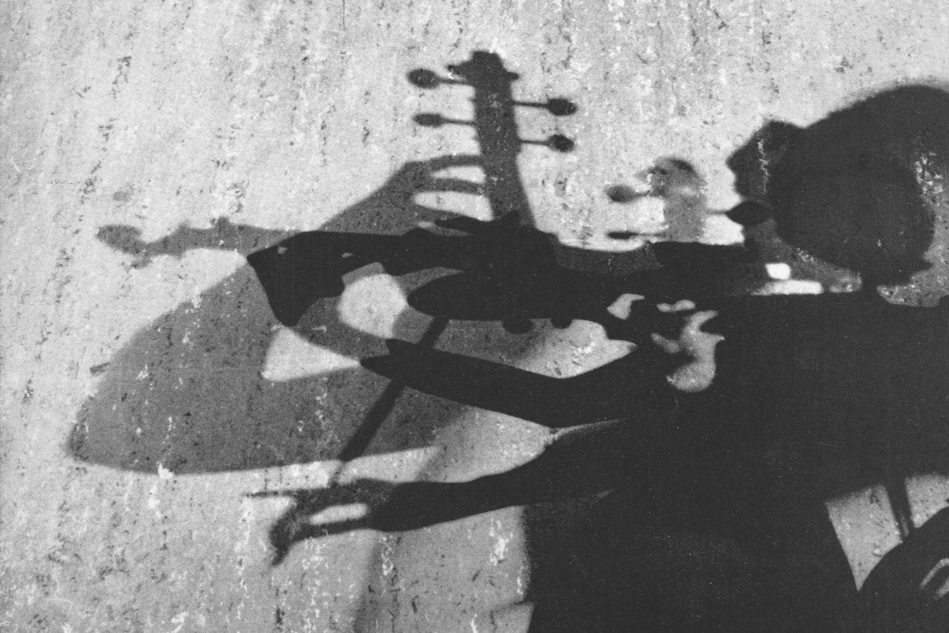 Sich mehrfach überlagendernde Schatten von einem Violine spielenden Mensch