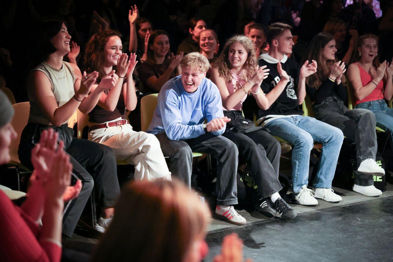 Young audience laughing and clapping.