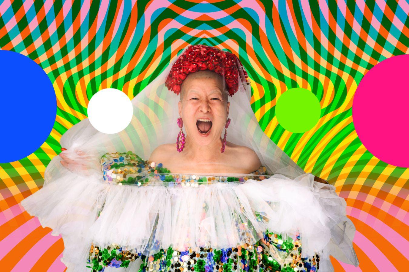 Eun-Me Ahn screams. She wears a headdress made of flowers and a colourful dress with tulle.
