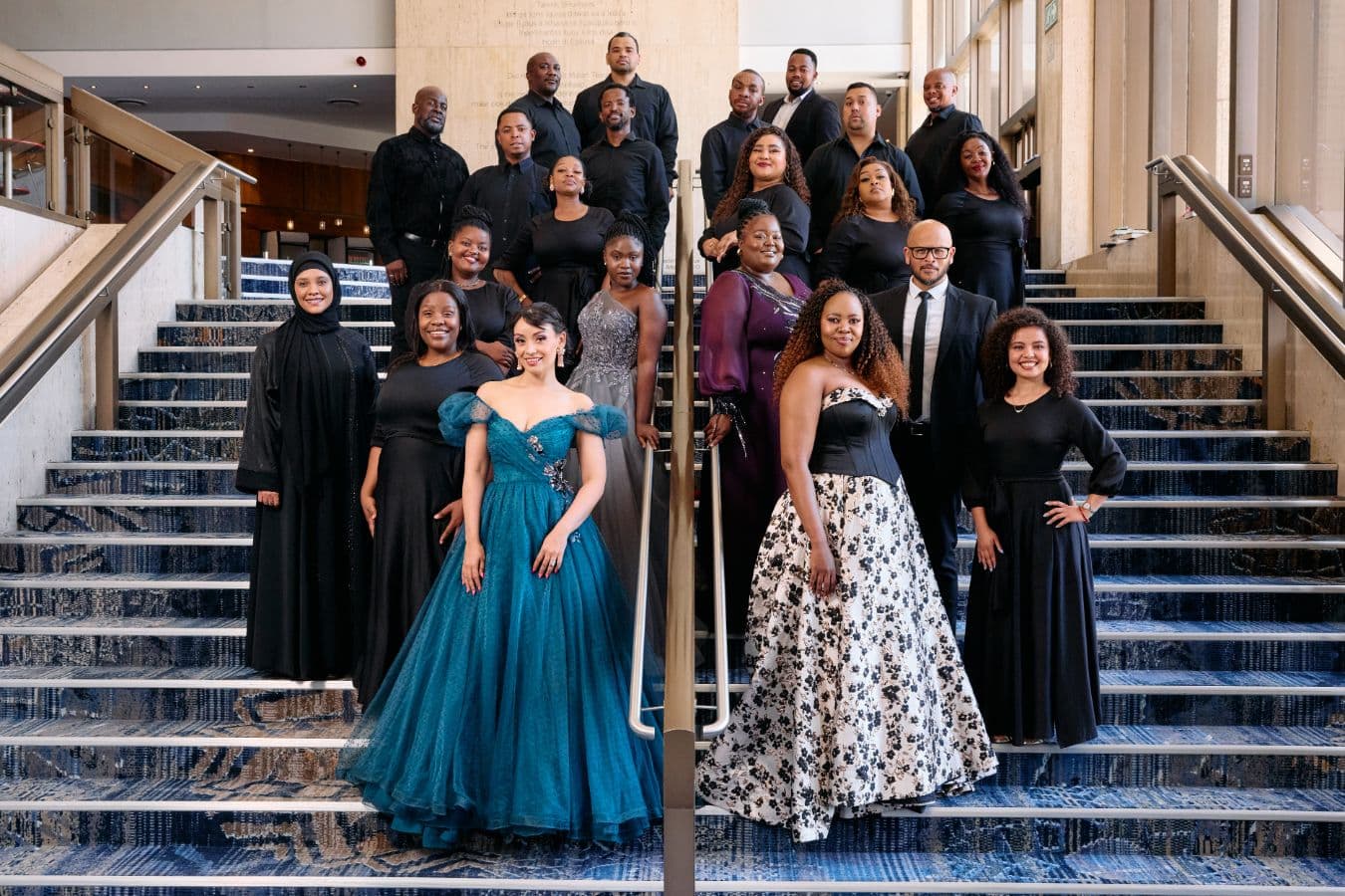 Group of people in evening attire and black clothing on a staircase.