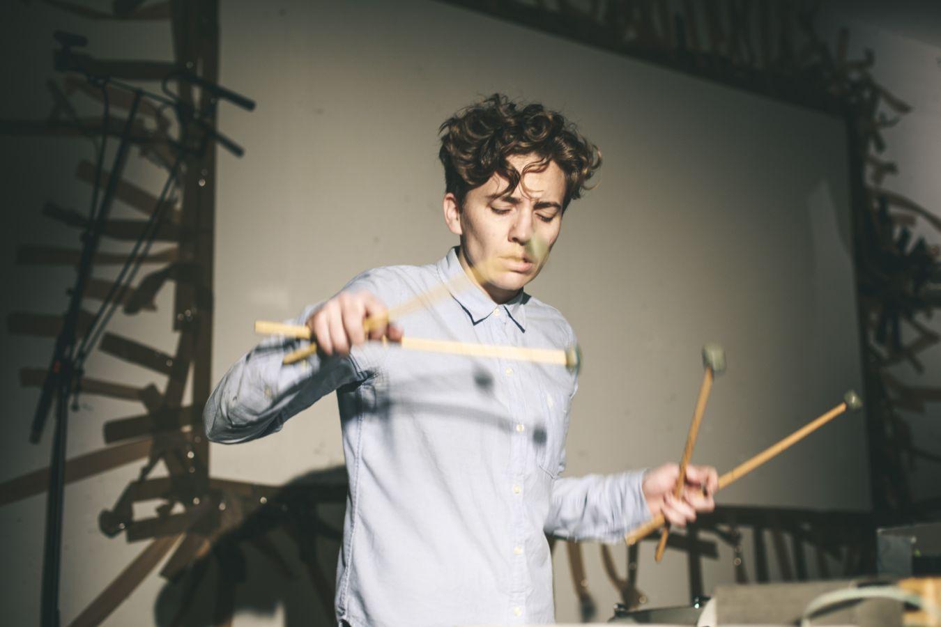 Jennifer Torrence trägt ein Hemd und spielt auf einem Schlagwerk