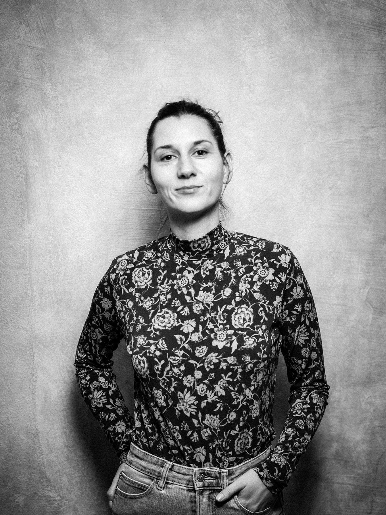 Black and white portrait of a woman in front of a white wall