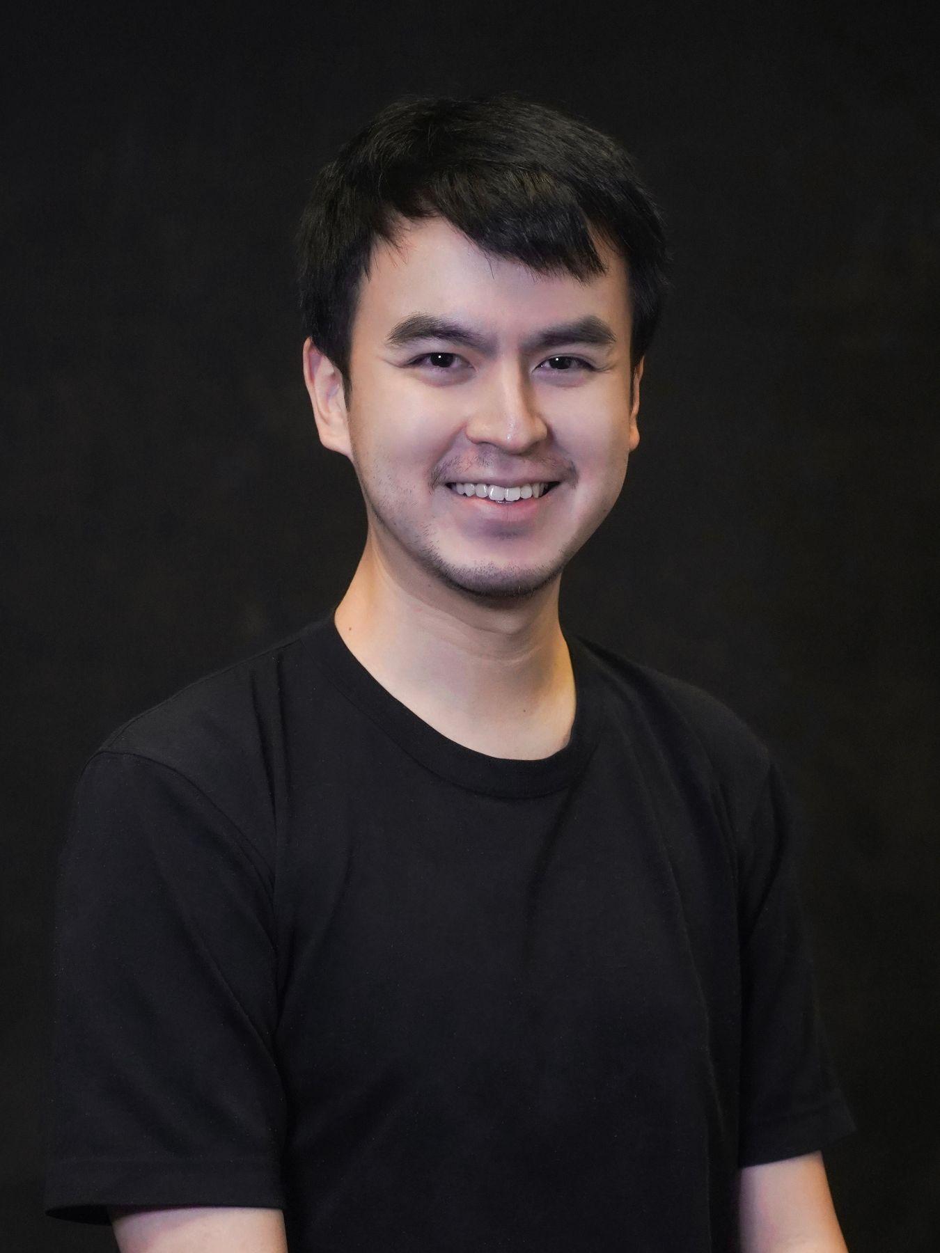 A man with short dark hair wearing a black t-shirt