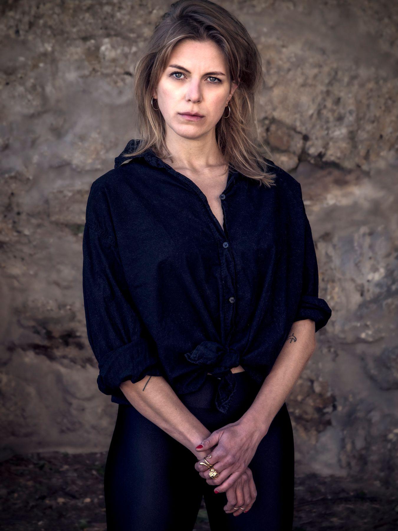 A young blonde woman in a black shirt.