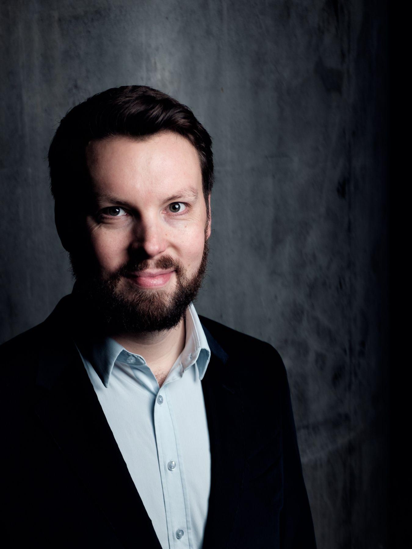 Porträt: Butt Philip hat einen Vollbart und dunkle Haare. Er trägt ein Hemd.