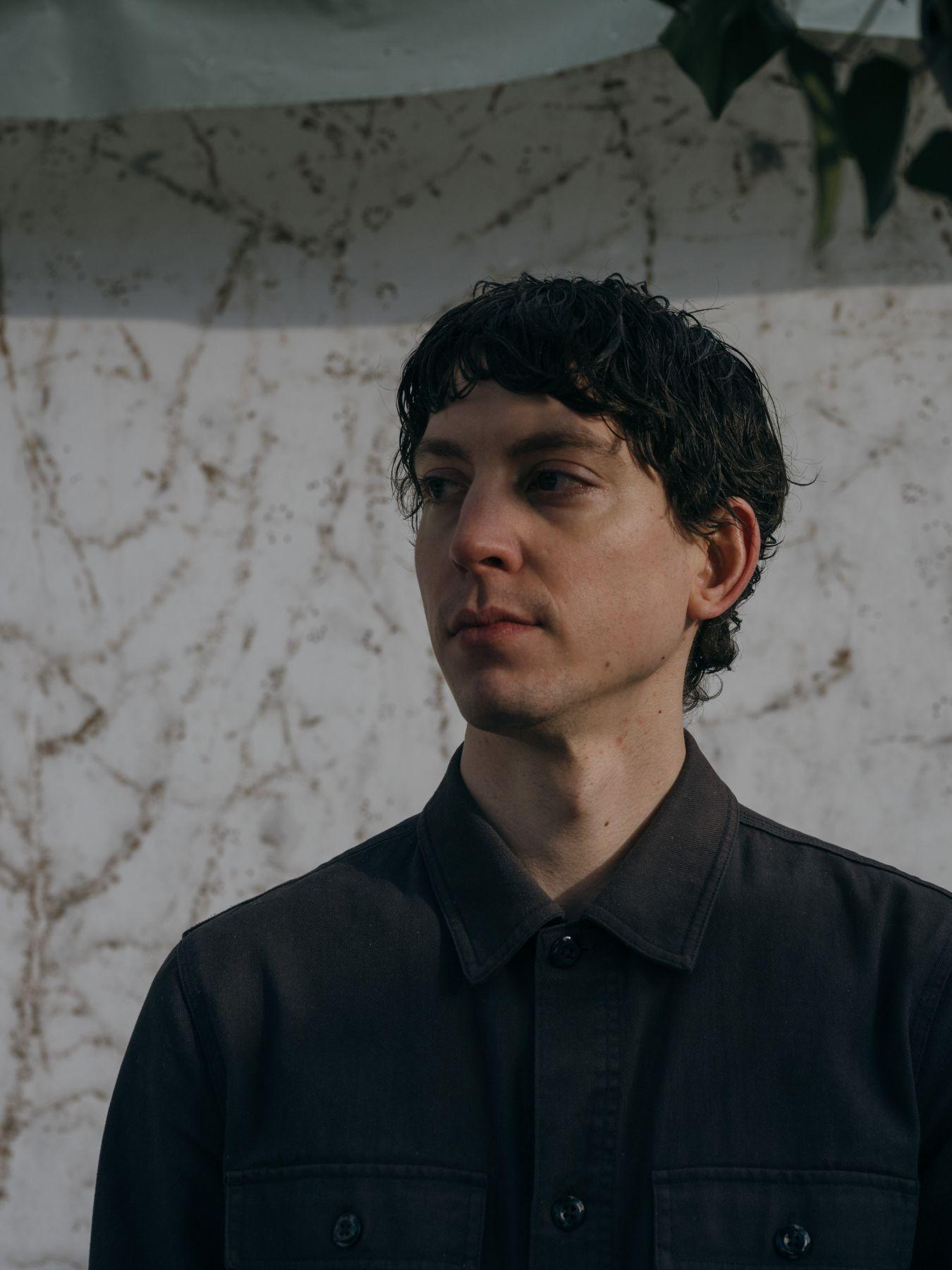 Salgado hat schwarze Haare und schaut nachdenklich zur Seite.