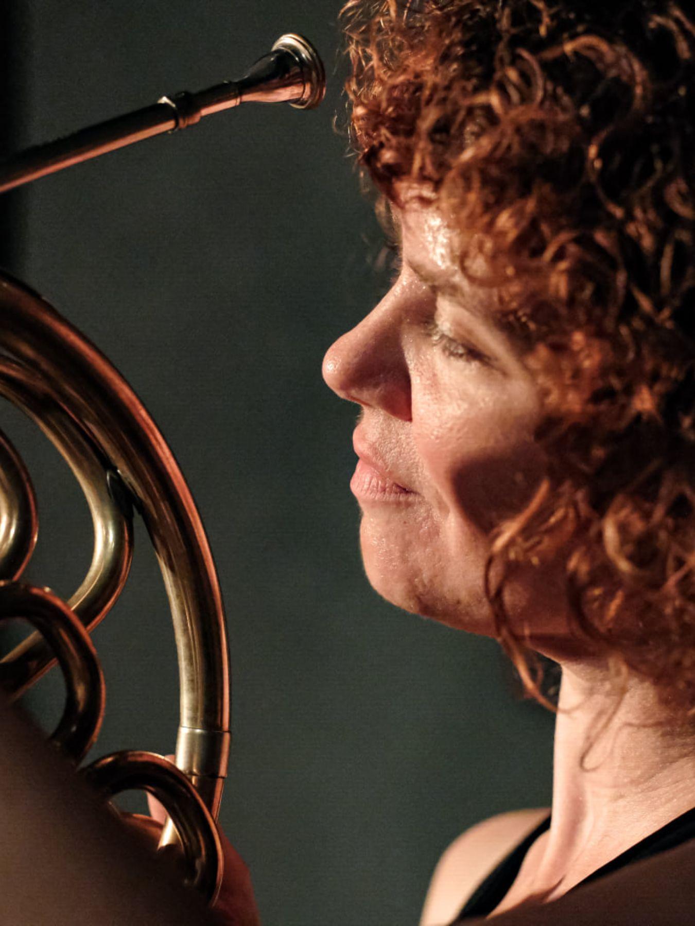 Kakaliagou hat rote Locken und schaut auf ihr Horn.