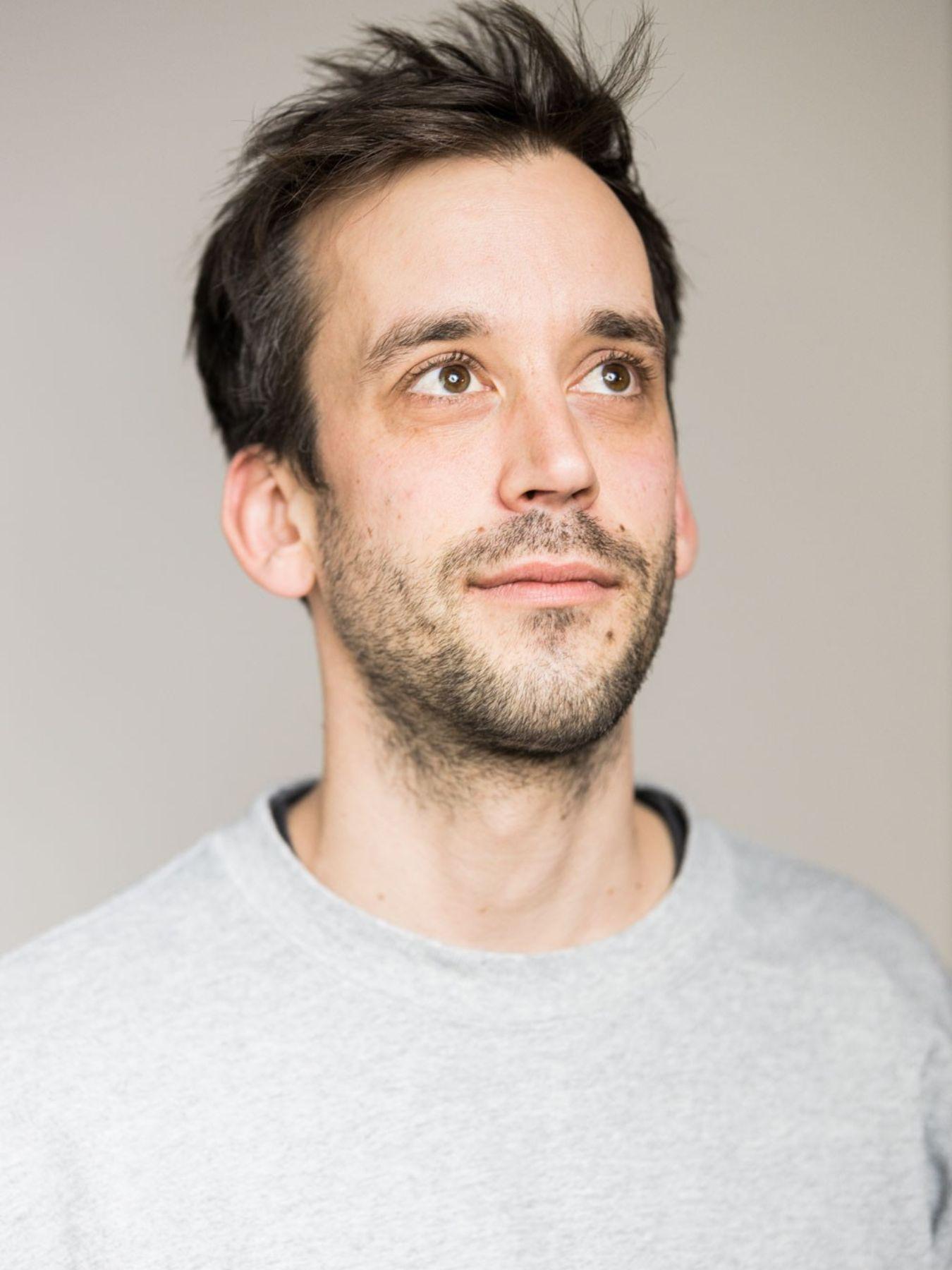 Portrait of a man in a grey shirt.