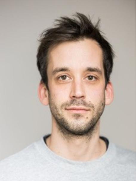 Portrait of a man in a grey shirt.