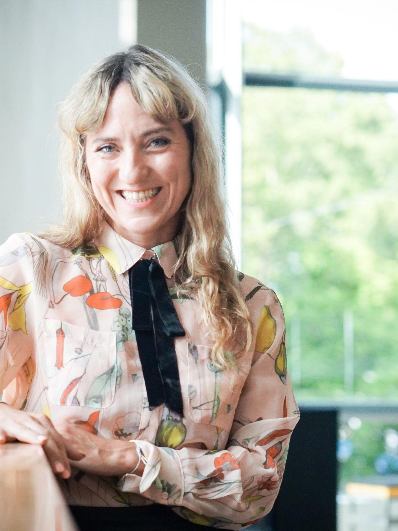 Lucia Bihler sitzt in einem Tische. Sie lächelt