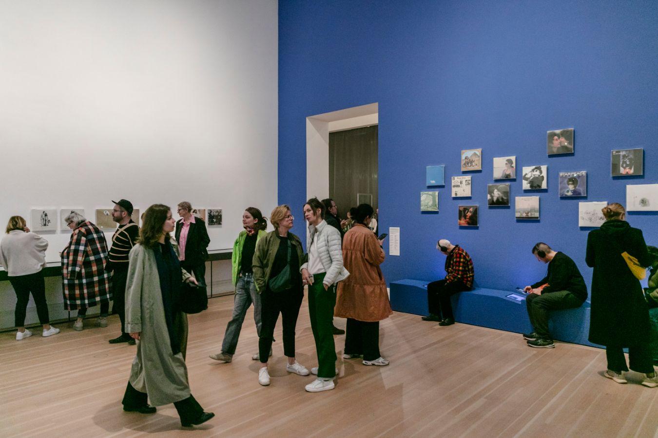 View of a room in the exhibition "YOKO ONO: MUSIC OF THE MIND" with visitors at Gropius Bau in Berlin.