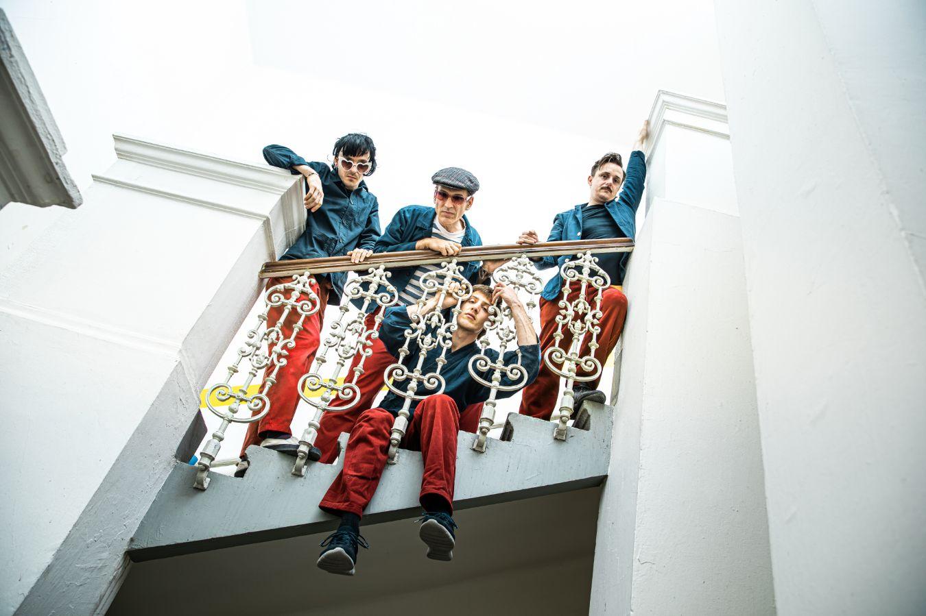 Die Mitglieder von Synesthetic4 Vincent Pongracz, Peter Rom, Manuel Mayr und Andreas Lettner posieren an einem Treppengeländer.