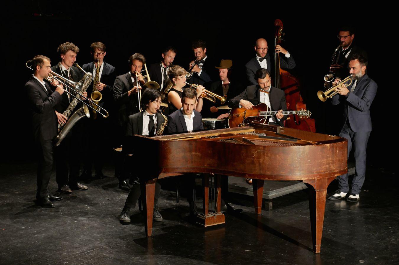 Die Umlaut Big Band in Aktion, wobei vorne der Flügel steht und sich die anderen Musiker dahinter platzieren.