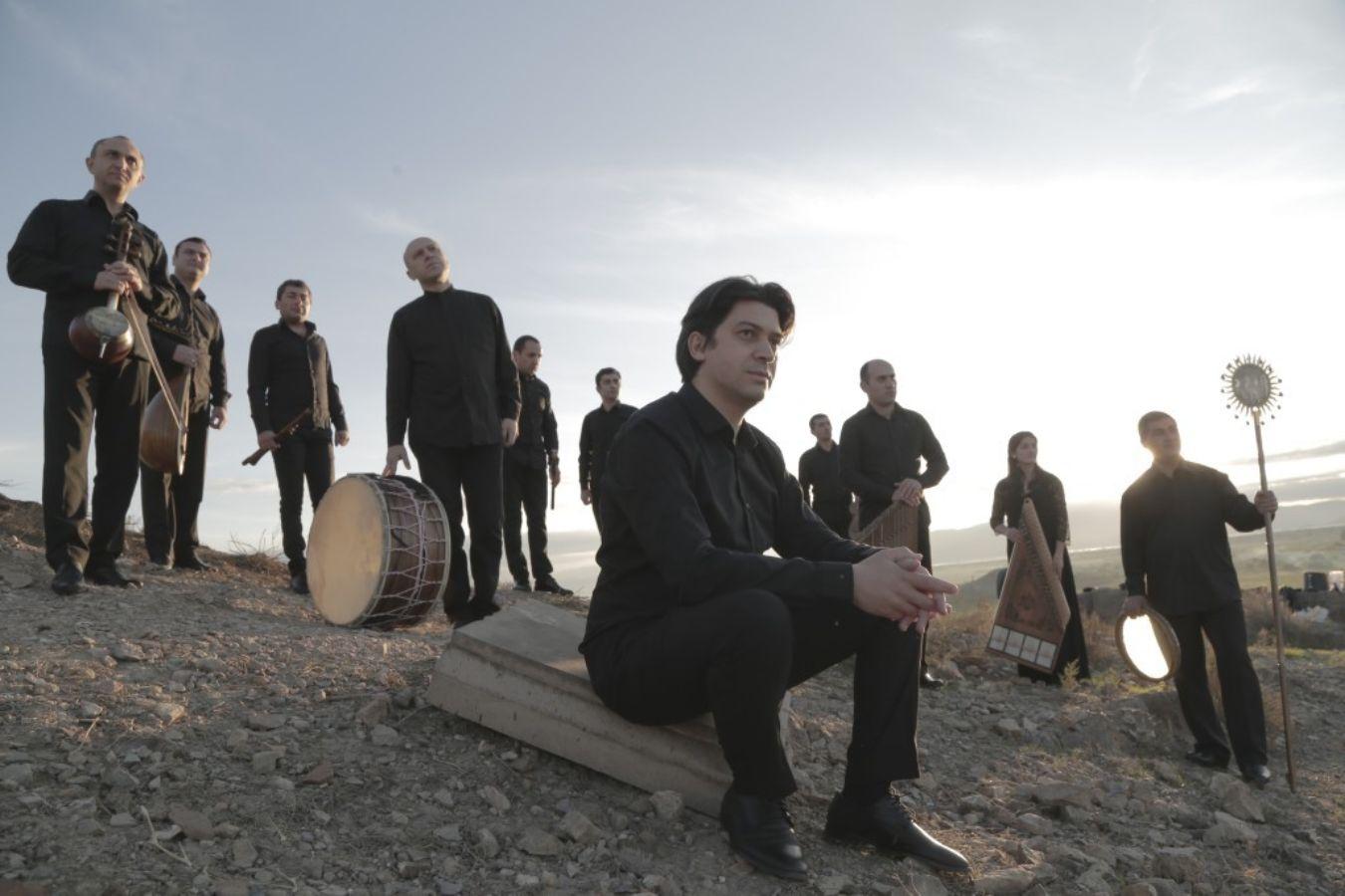 Portrait of the members of the Gurdjieff Ensemble in a barren, stony landscape.