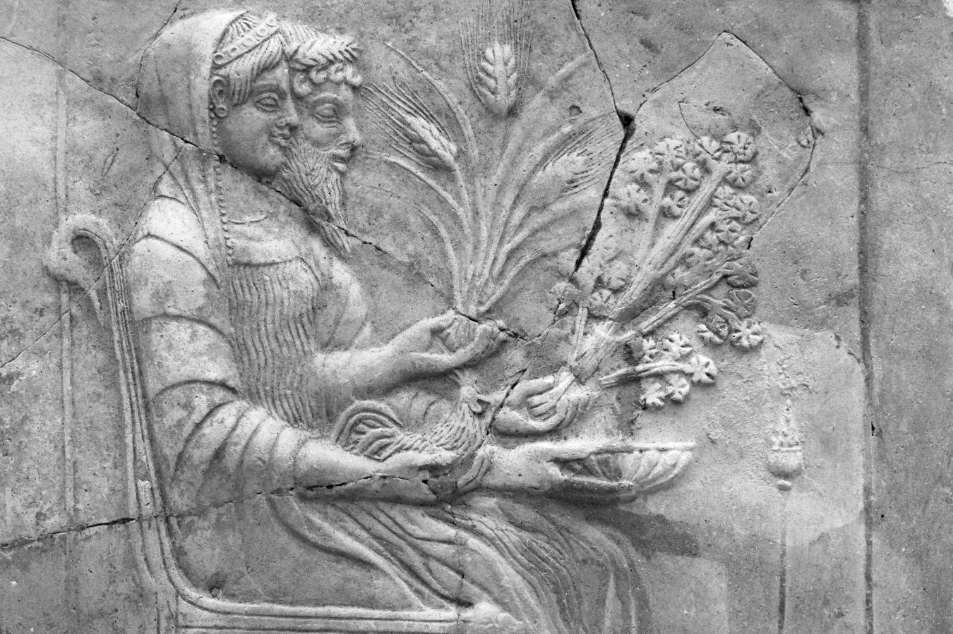 Zwei Menschen auf einem Thron halten Getreide-Ähren.