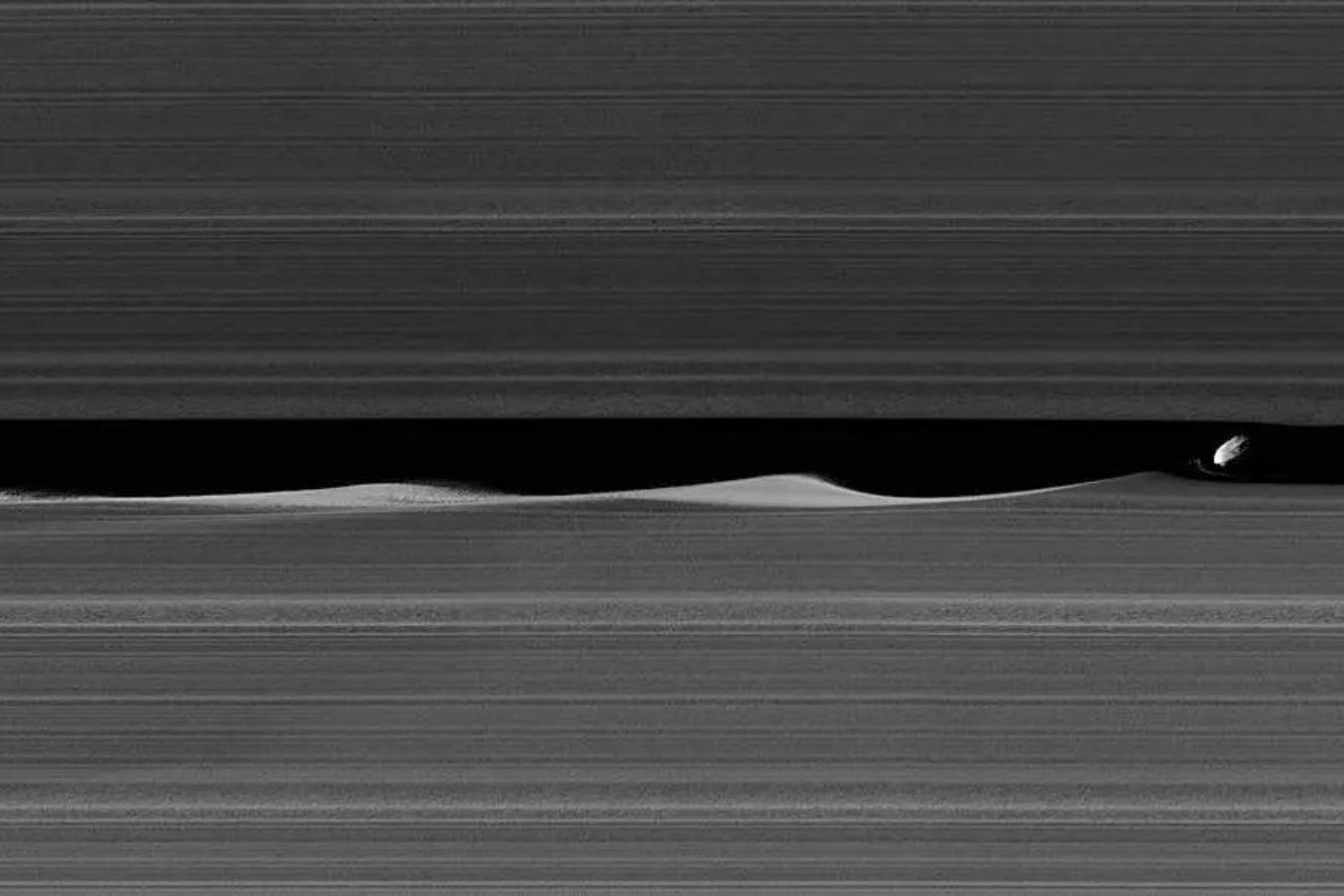 Image from space with Saturn’s rings and Saturn’s moon.