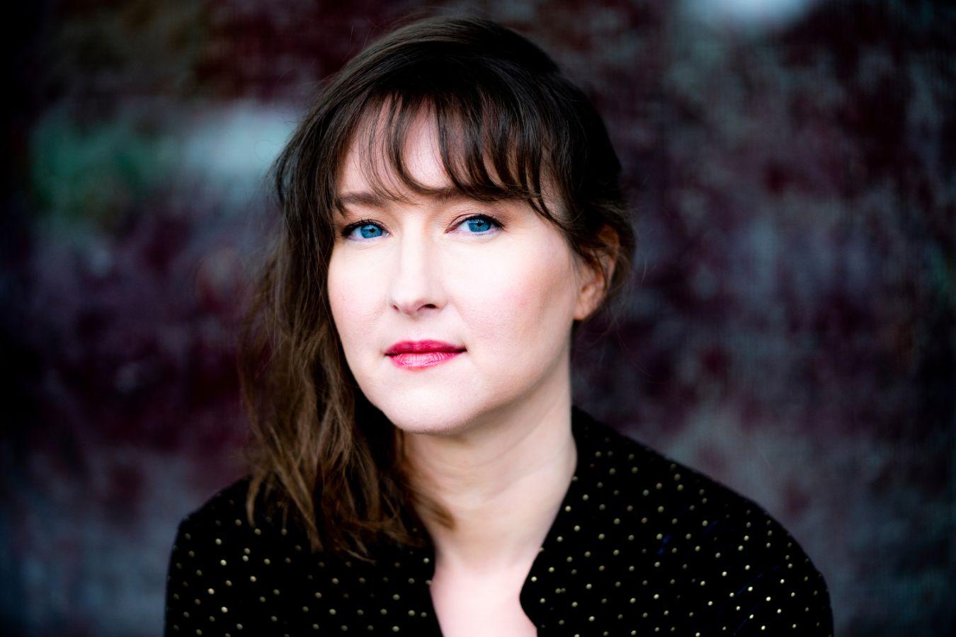 Fotografie mit der Komponistin Lisa Streich, deren dunkle Haare und blauen Augen einen starken Kontrast bilden.