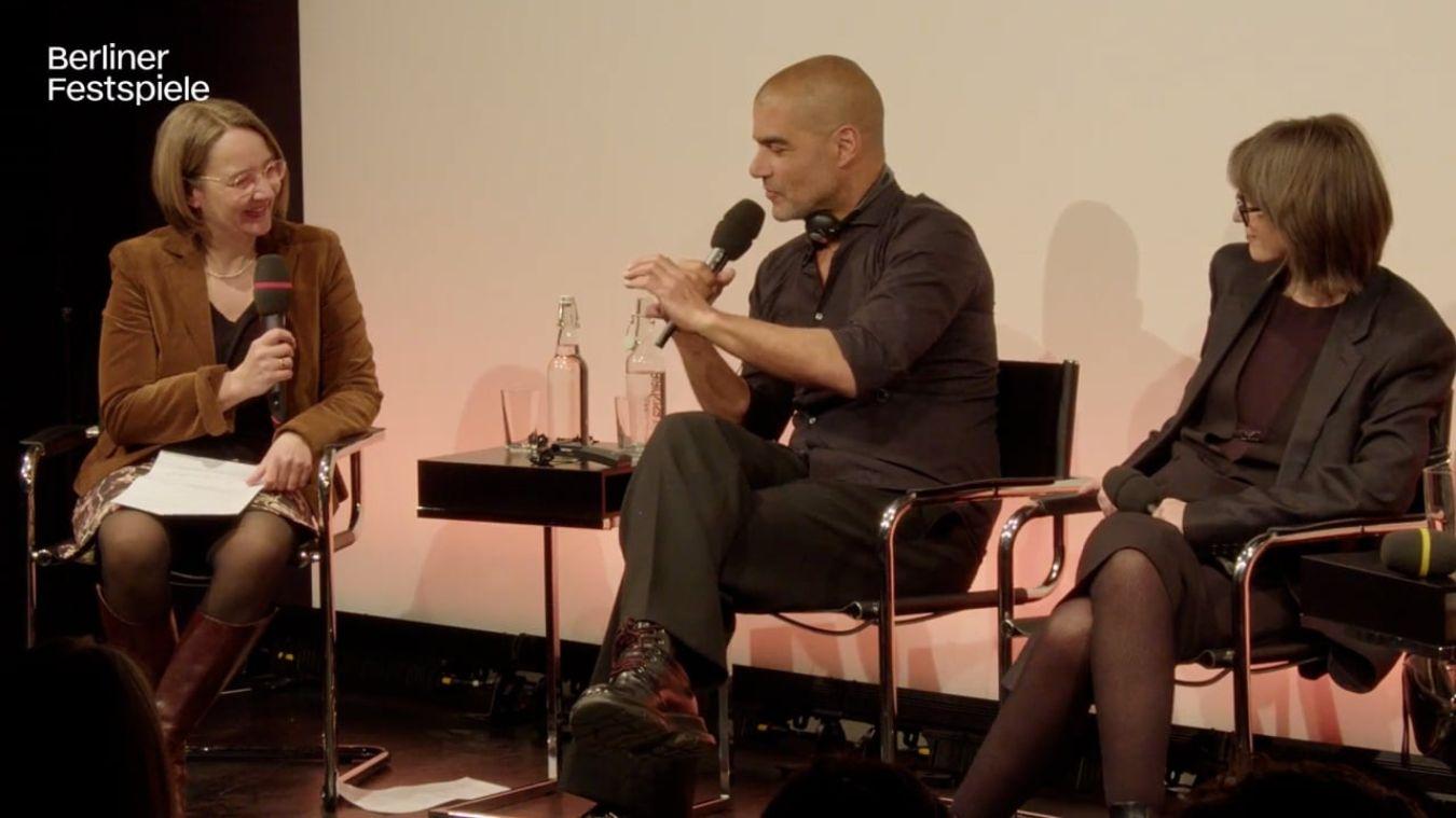 People sit on a stage and look at each other.