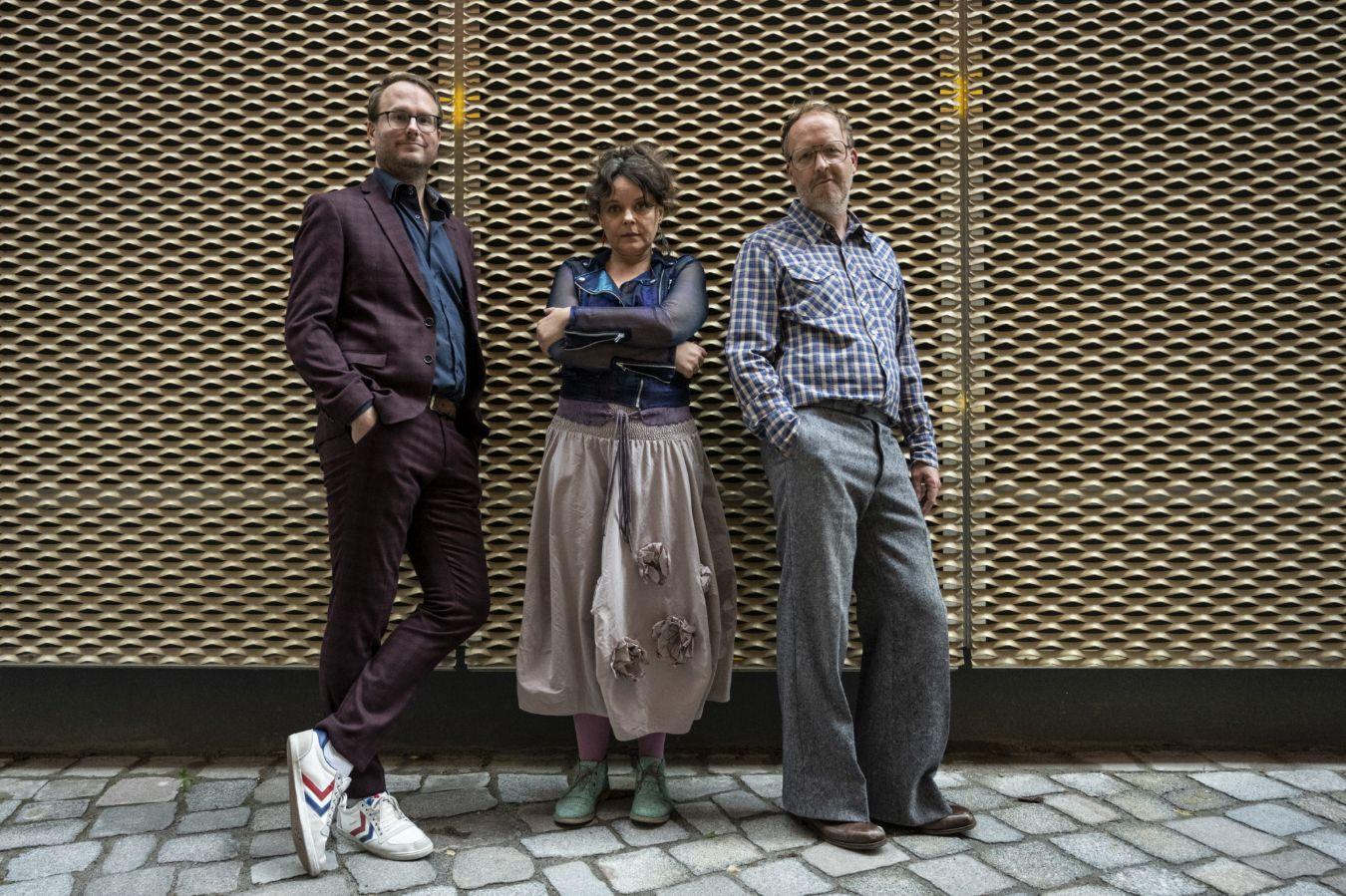 Das Trio „Vesna“ (Frühling) um Mariana Sadovska vor einer Fassade mit starkem Relief. Sie hält die Arme verschränkt. Rechts und links von ihr lehnen sich Christian Thomé und Markus Braun in locker Haltung an die Wand.