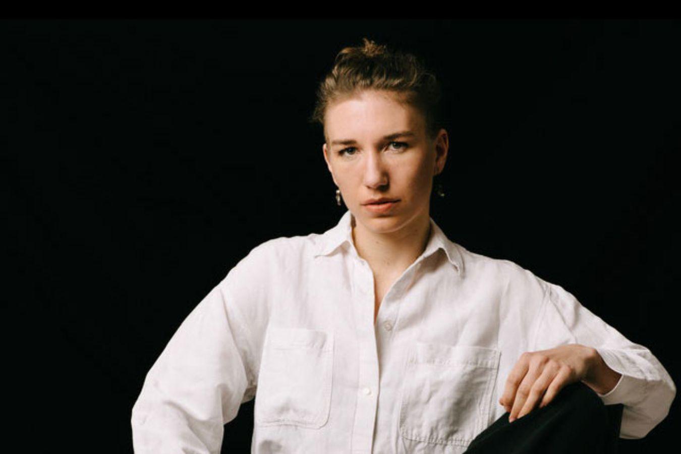 Mirjam Stängl sitzend, die linke Hand liiegt auf ihrem linken Knie