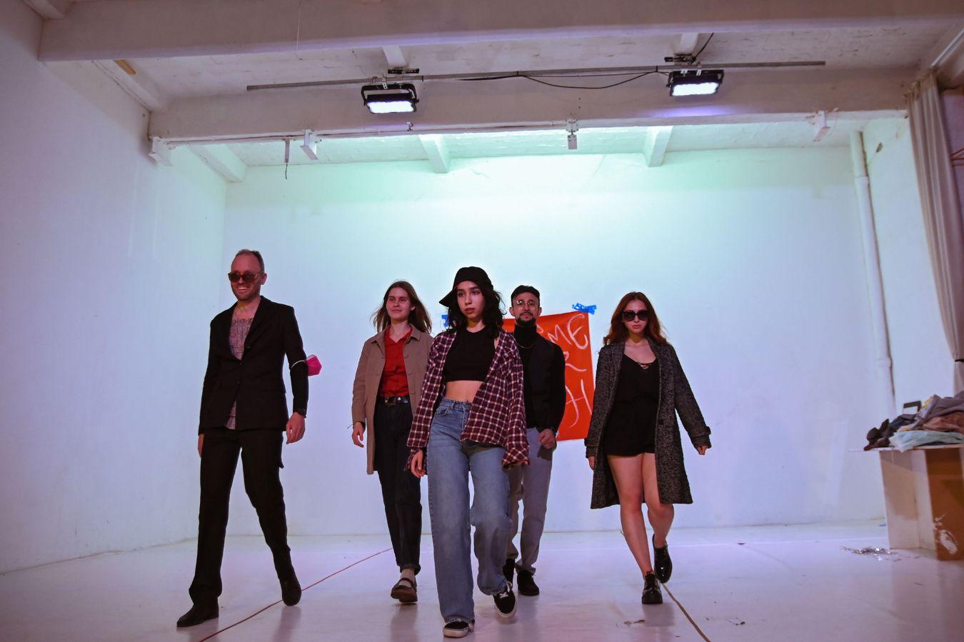 Fünf Personen gehen dynamisch durch einen Raum.