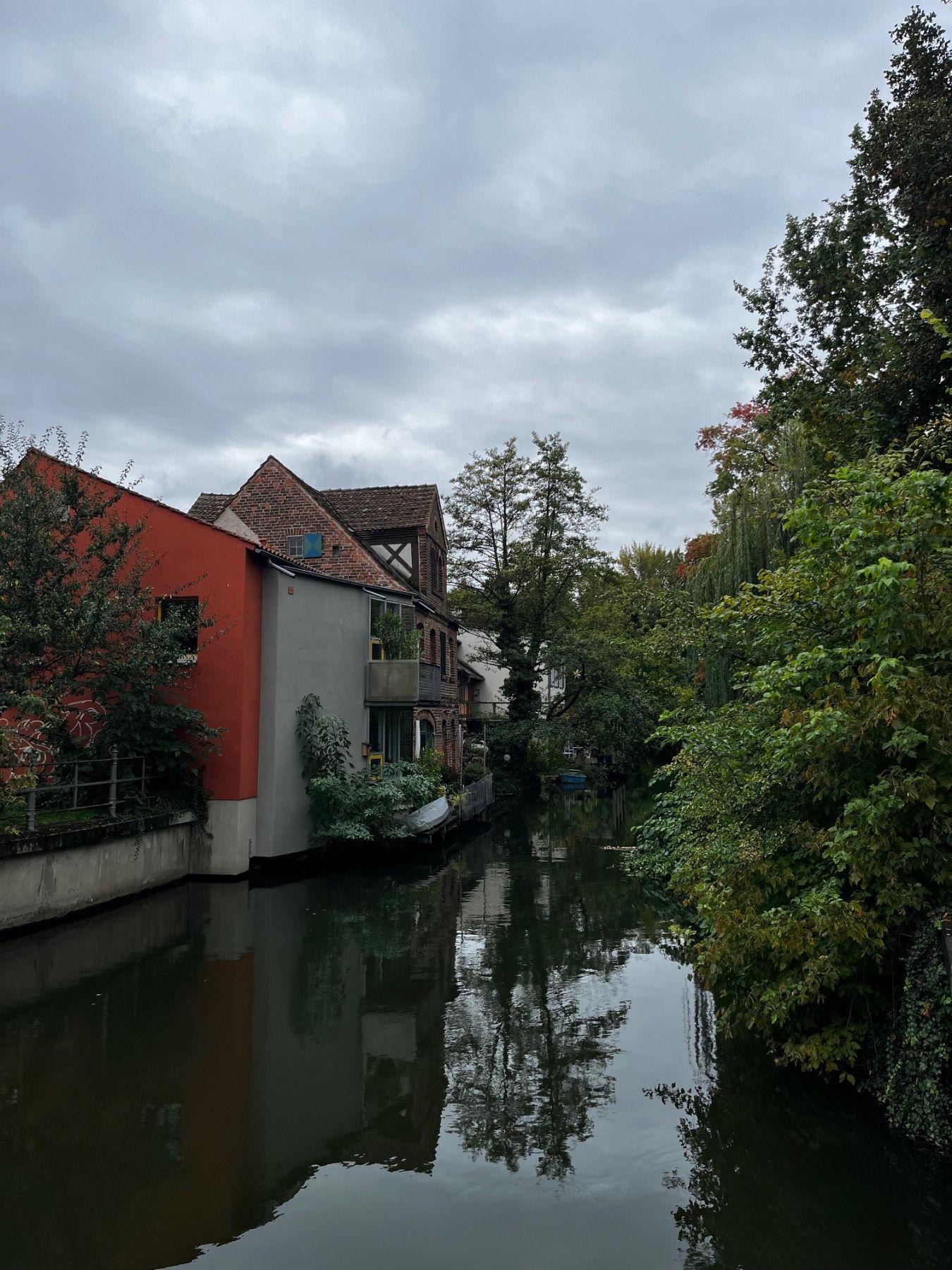 Tanners’ houses stand by an idyllic body of water with many deciduous trees