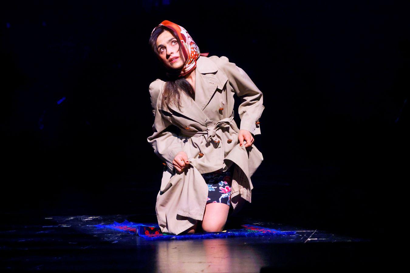 Eine Frau kniet auf einem Teppich und wendet ihren Blick nach oben