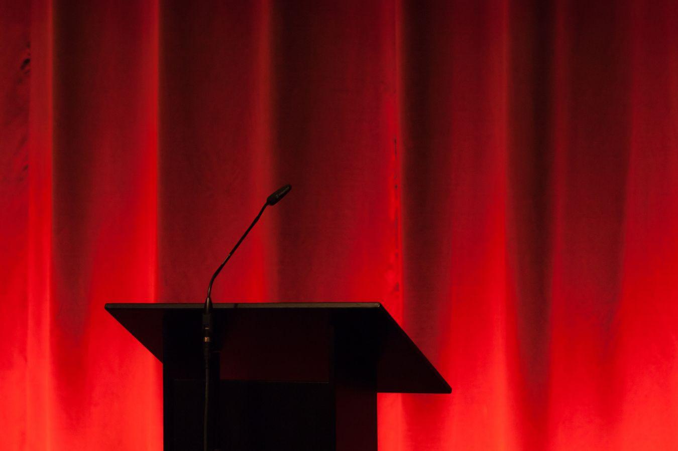 Lectern in front of a red curtain