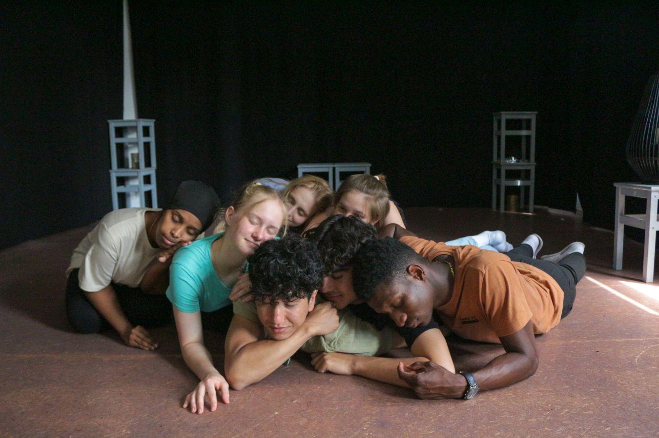 Sieben Personen liegen auf dem Bühnenboden. Sie haben die Augen geschlossen und sind innig, vertraut und nah.