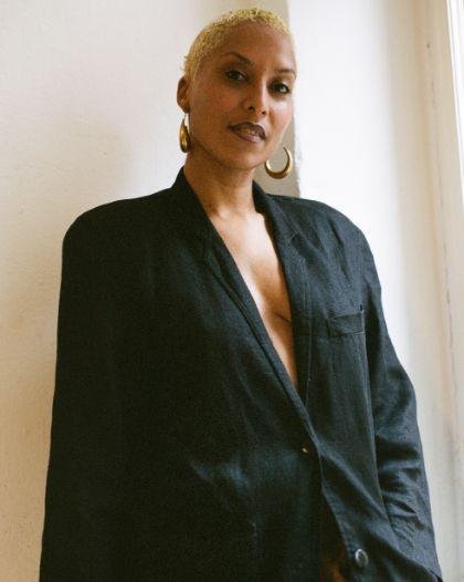 Portrait of Lewis with a black blazer and blond, short hair.