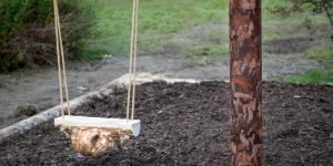 A swing with a wooden block as a seat