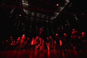 Das Publikum bewegt sich auf der Bühne. Über ihm liegt der Schnürboden.