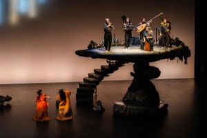 A staircase leads up to a high, rock-like platform where a quintet is playing.