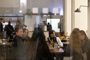 Die Räumlichkeiten des Restaurants Beba im Gropius Bau. An den Tischen sitzen Menschen, die sich unterhalten.
